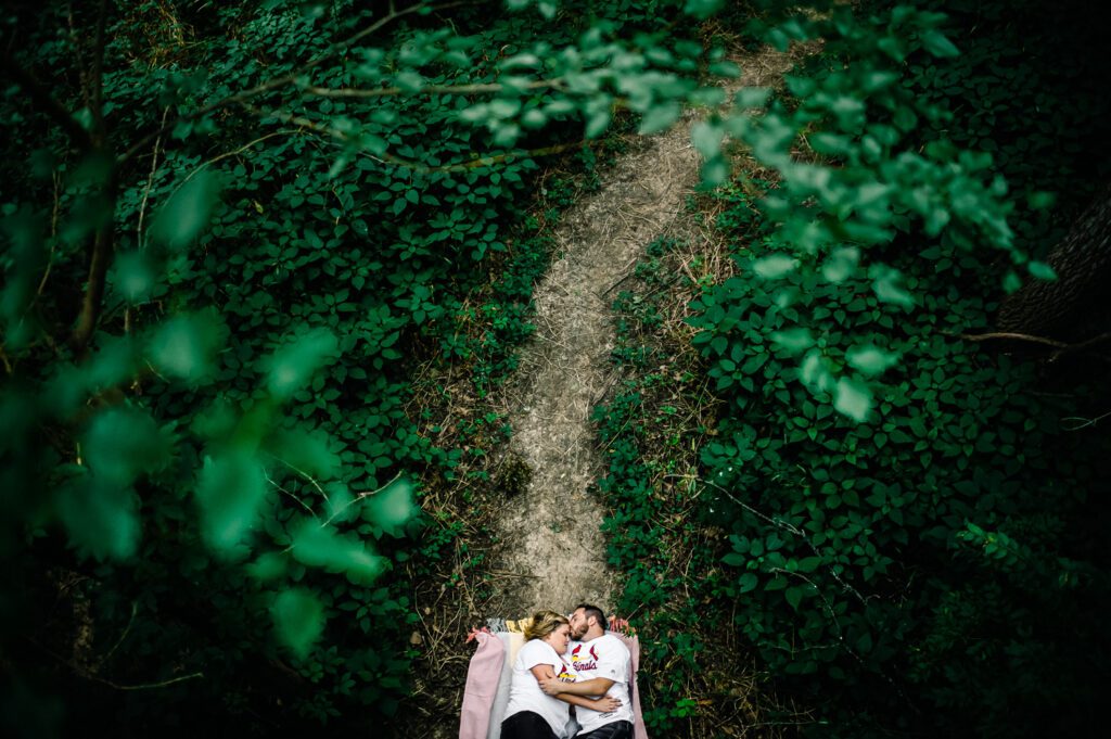 couple laying on ground wearing Cardinals jersey