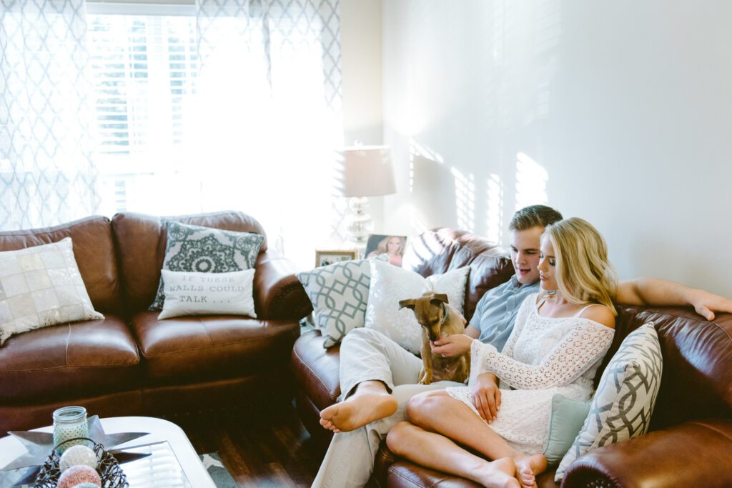 couple sitting on couch with dog