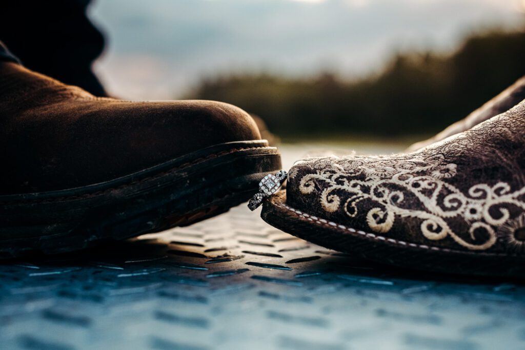 cowboy boots holding engagement ring