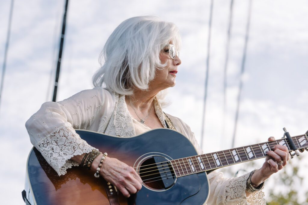Emmylou Harris looking at guitar
