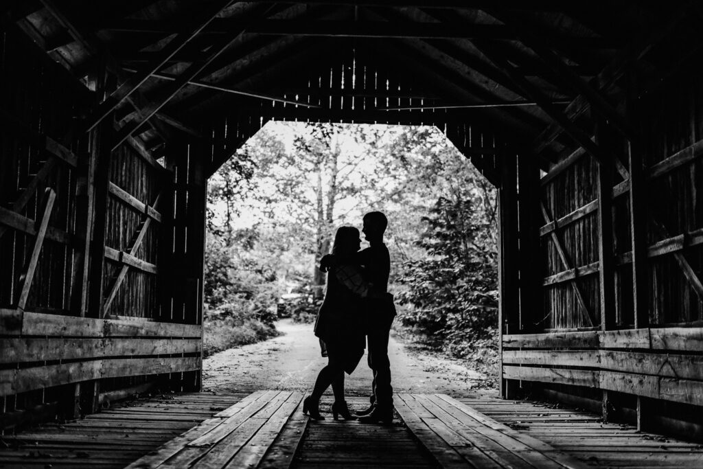 shadow of couple holding each other covered bridge