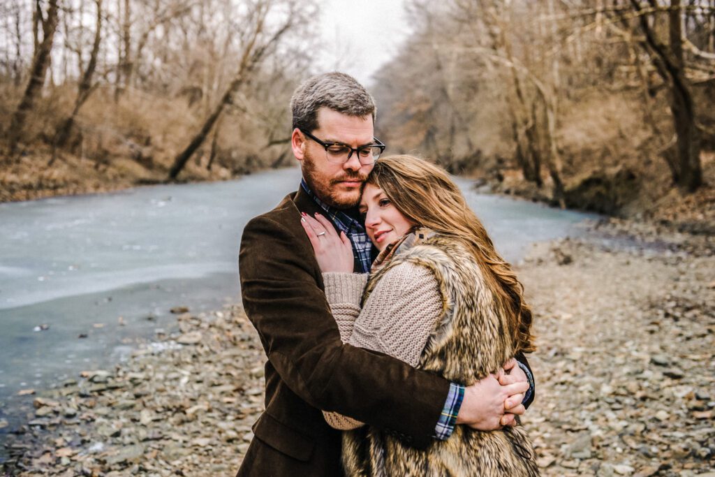 couple hugging in front of frozen creek