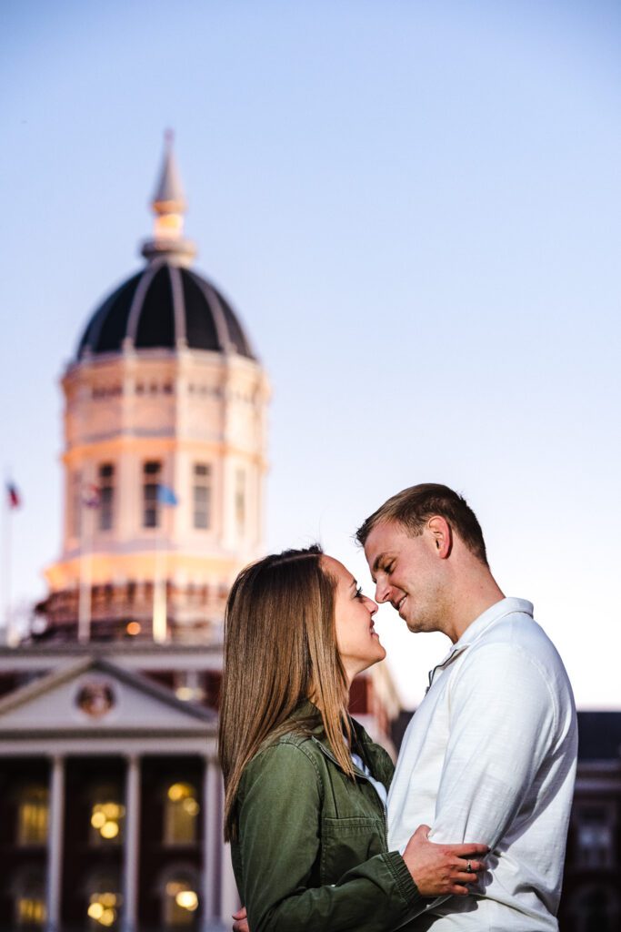 engaged couple hugging in front of Mizzou