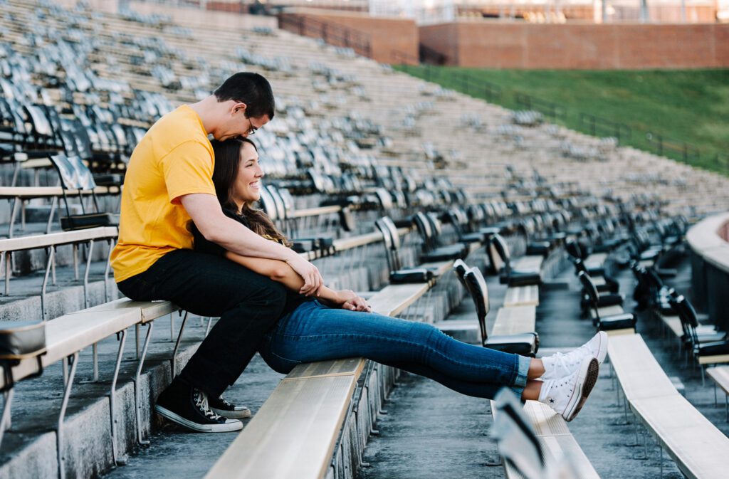 boy kissing girls head at Mizzou stadium bleachers