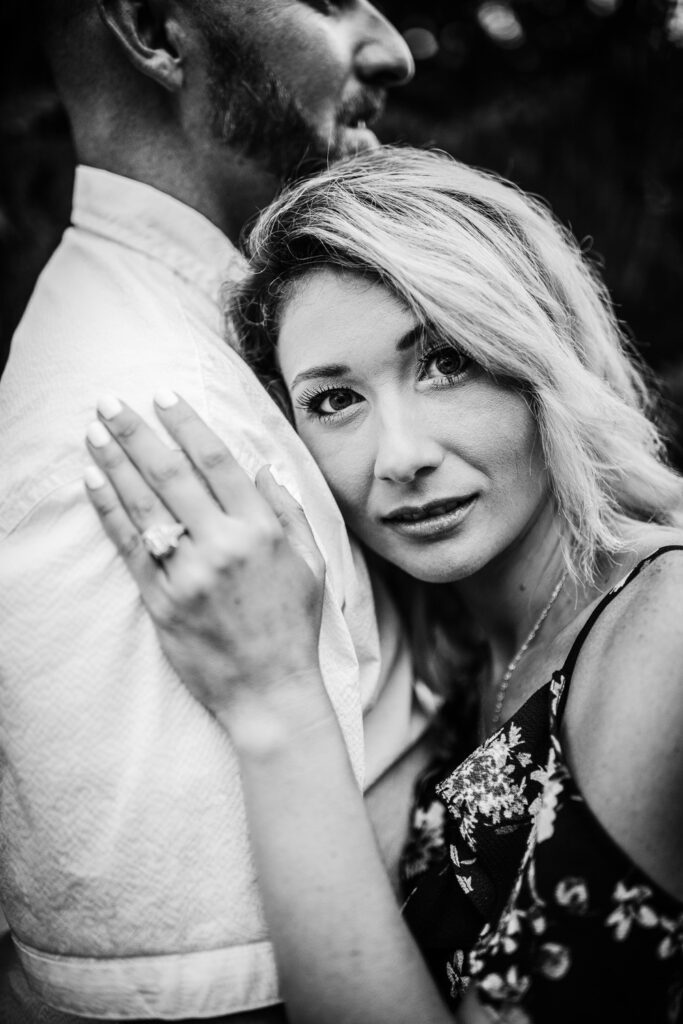 girl looking on engagement ring on fiance shoulder