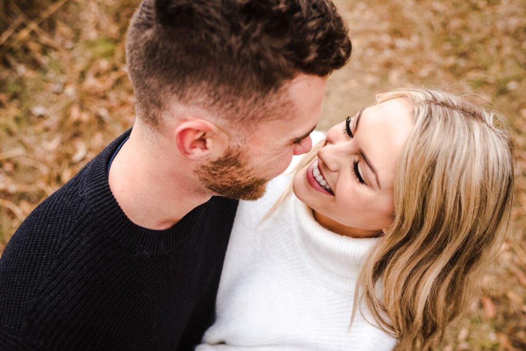 engaged couple laughing and smiling at each other