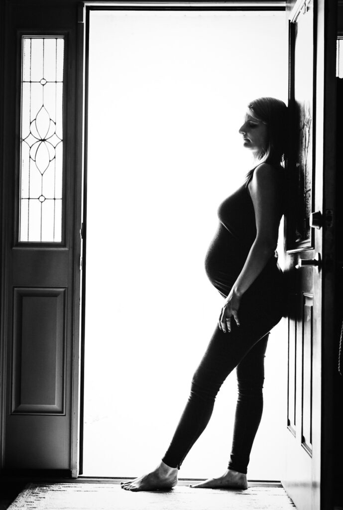 pregnant woman standing in doorway