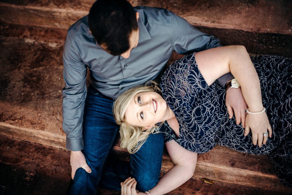 pregnant couple laying on bench