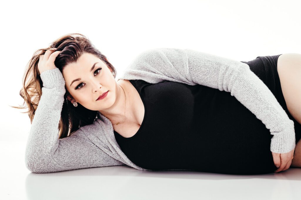 gorgeous woman laying on floor holding stomach