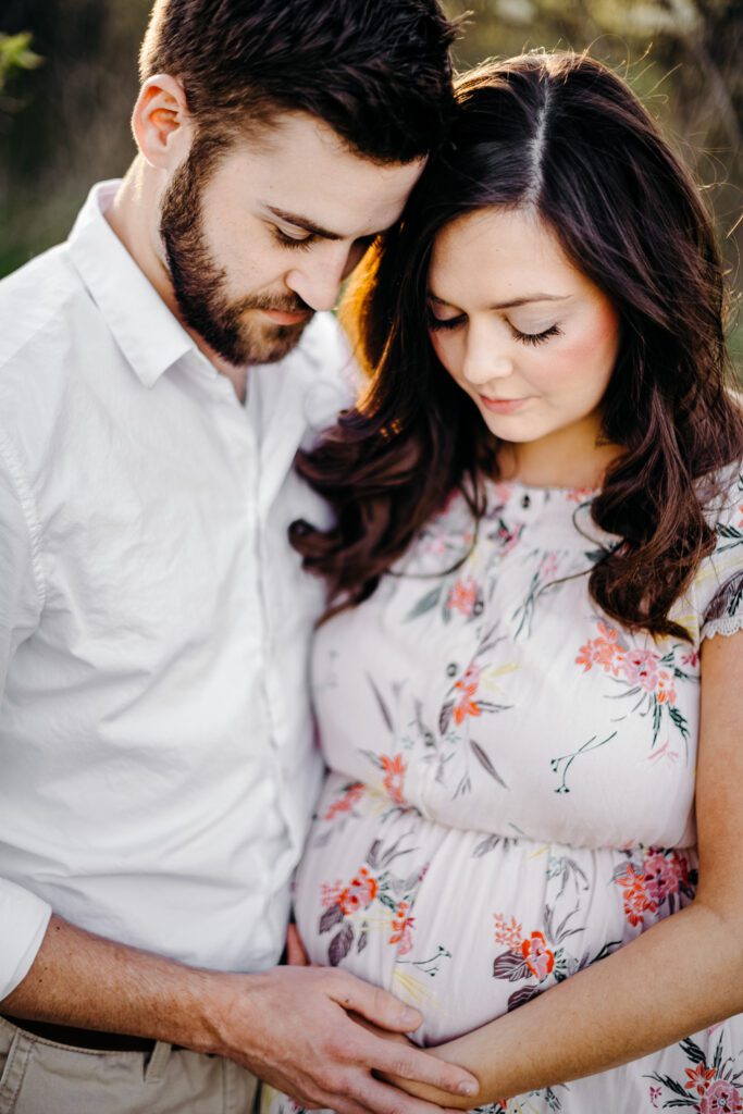 expecting parents heads together looking a baby bump