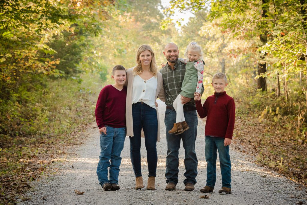family hugging in woods gravel road Columbia, MO