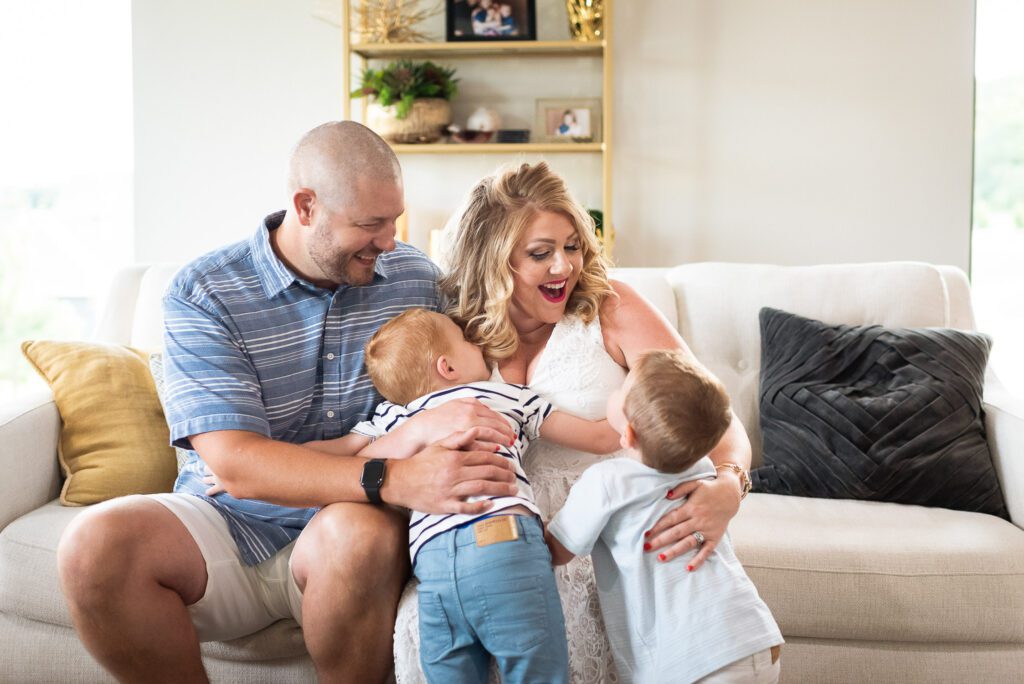 mother and father laughing with kids in living room setting Columbia, MO