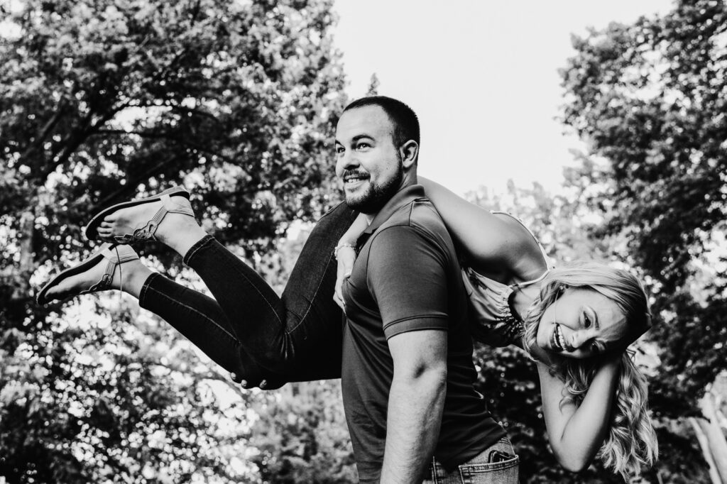 fiance throws girl over shoulder laughing