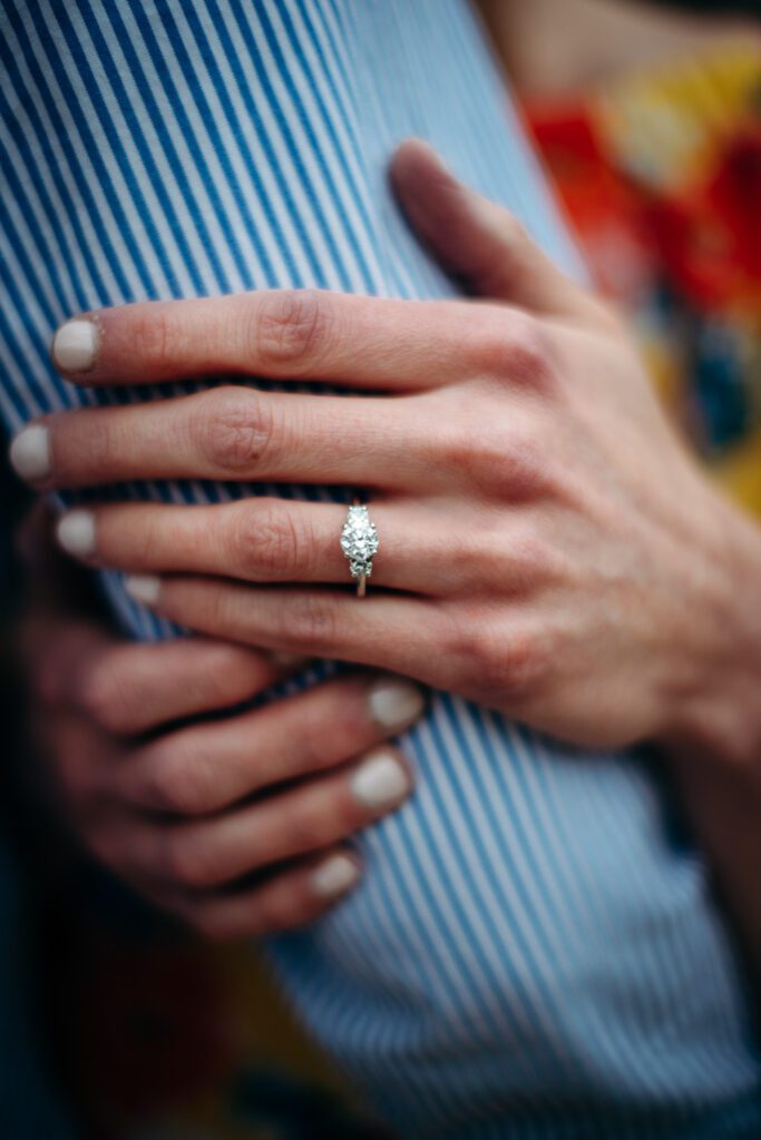 girl holding arm showing engagement ring