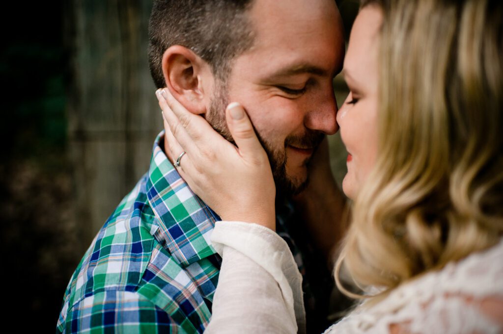 girl holding fiance's face with noses touching