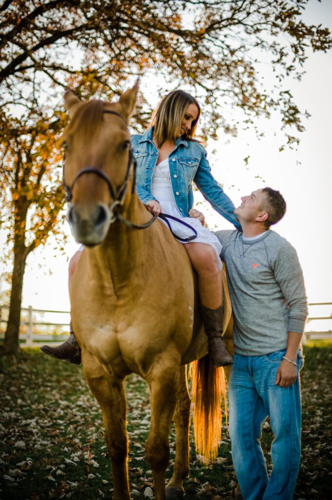 girl looking down at fiance while riding horse