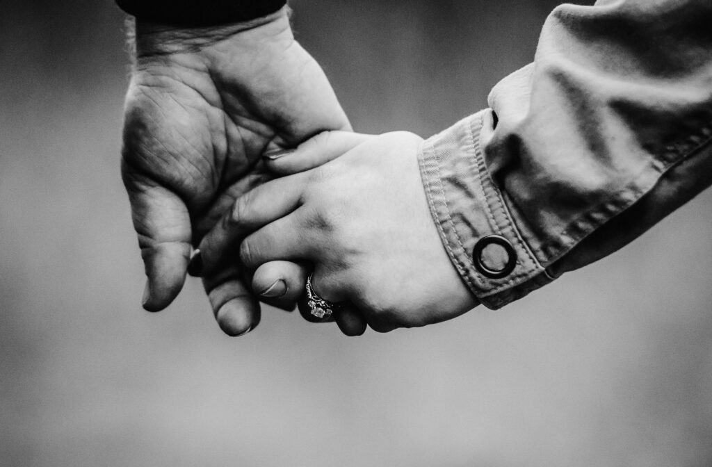 holding hands showing engagement ring