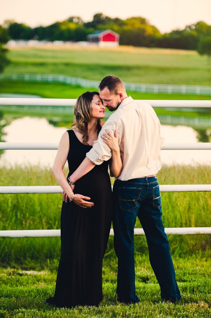 husband holding pregnant wife in front of Warm Springs Ranch Boonville, MO