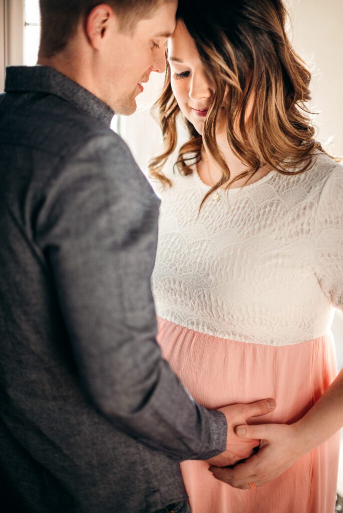 husband holding wife's pregnant stomach