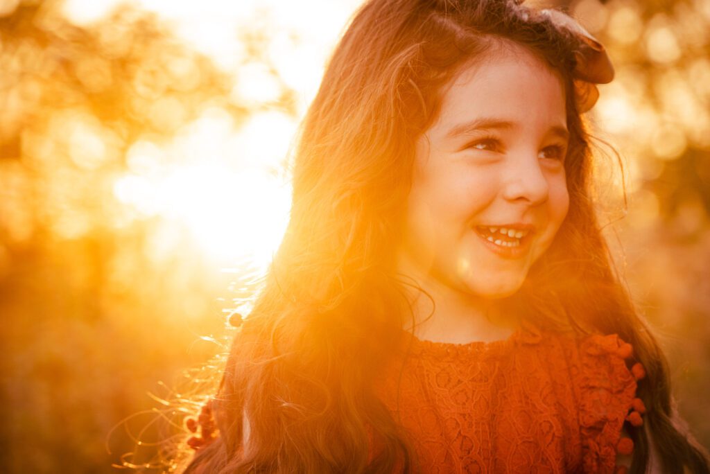 little girl smiling in evening sunset