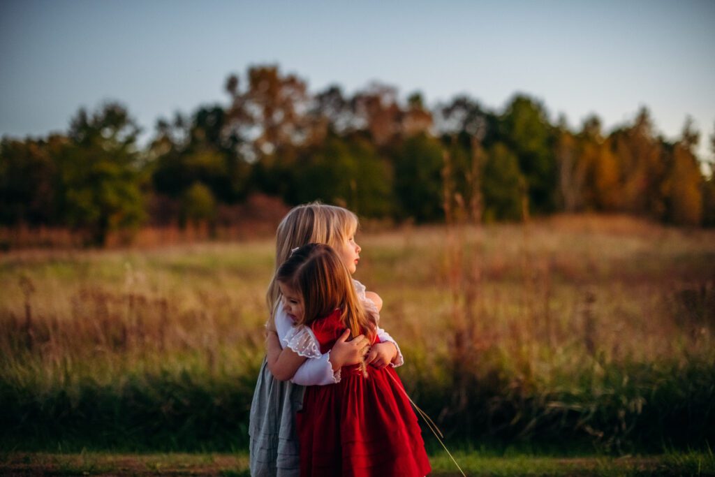 little girls hugging as sunsets