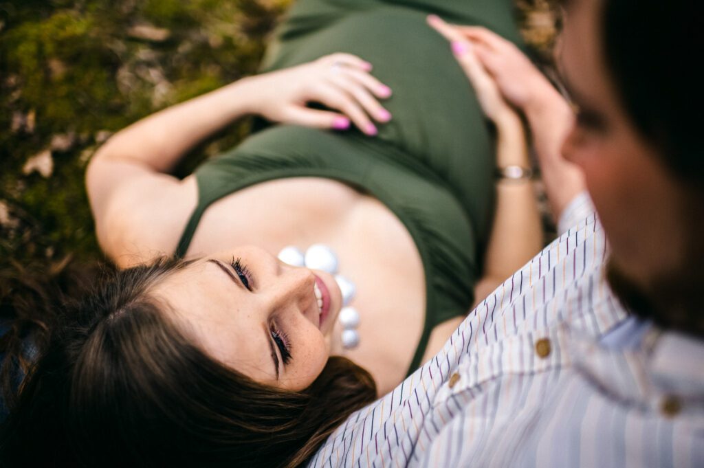 pregnant couple laying in field
