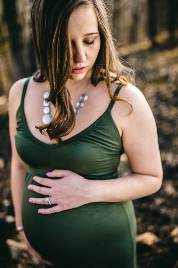 pregnant woman hand on green dress