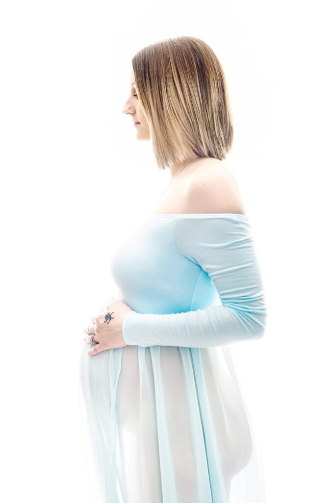 pregnant woman in sheer dress white background