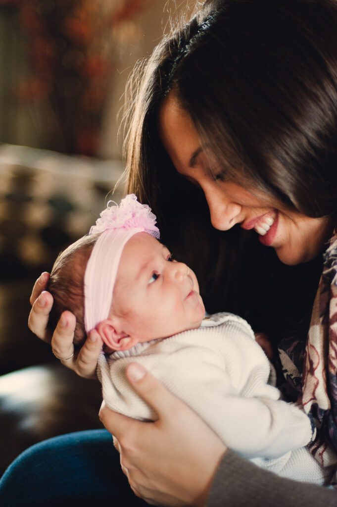 Newborn smiling at mom holding her at home in Columbia, MO
