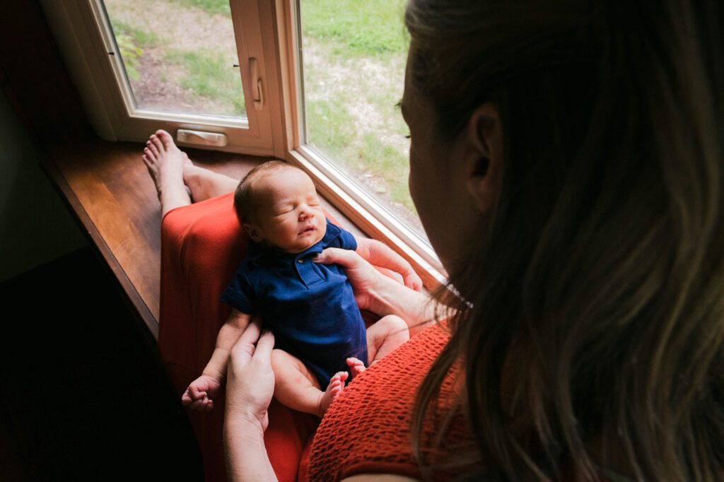 mother and newborn son sitting in window seat