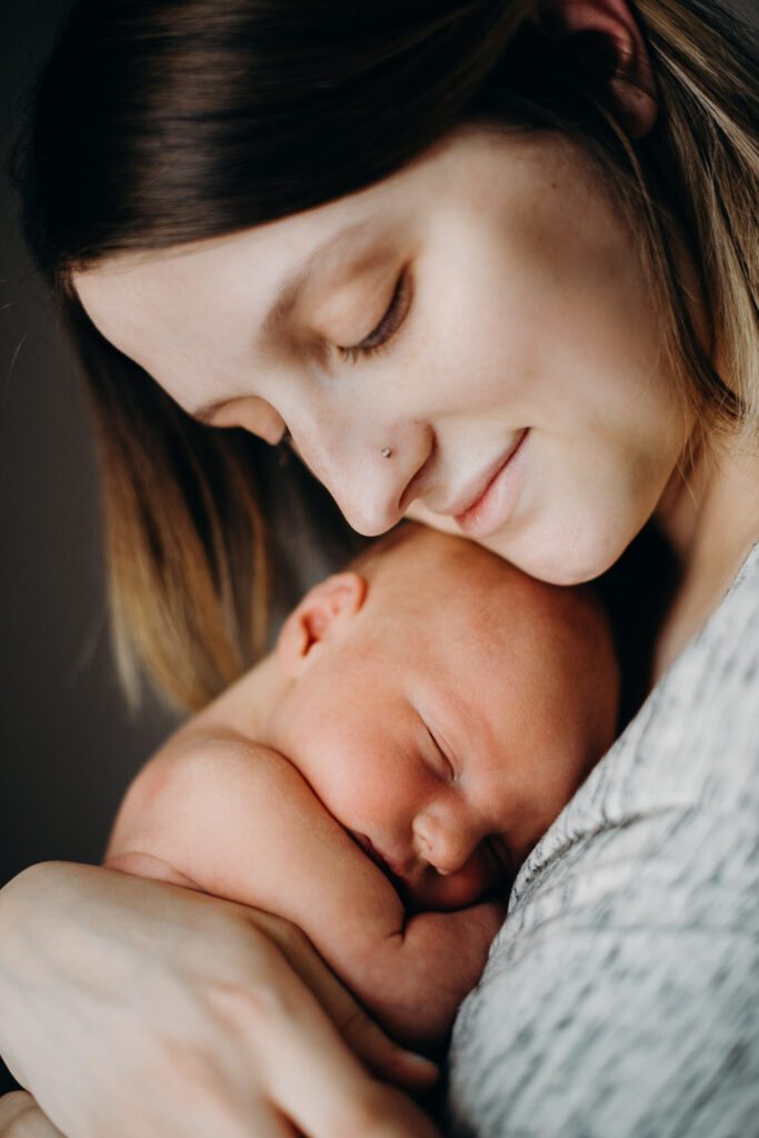 new mom snuggling baby to her face in Columbia, MO