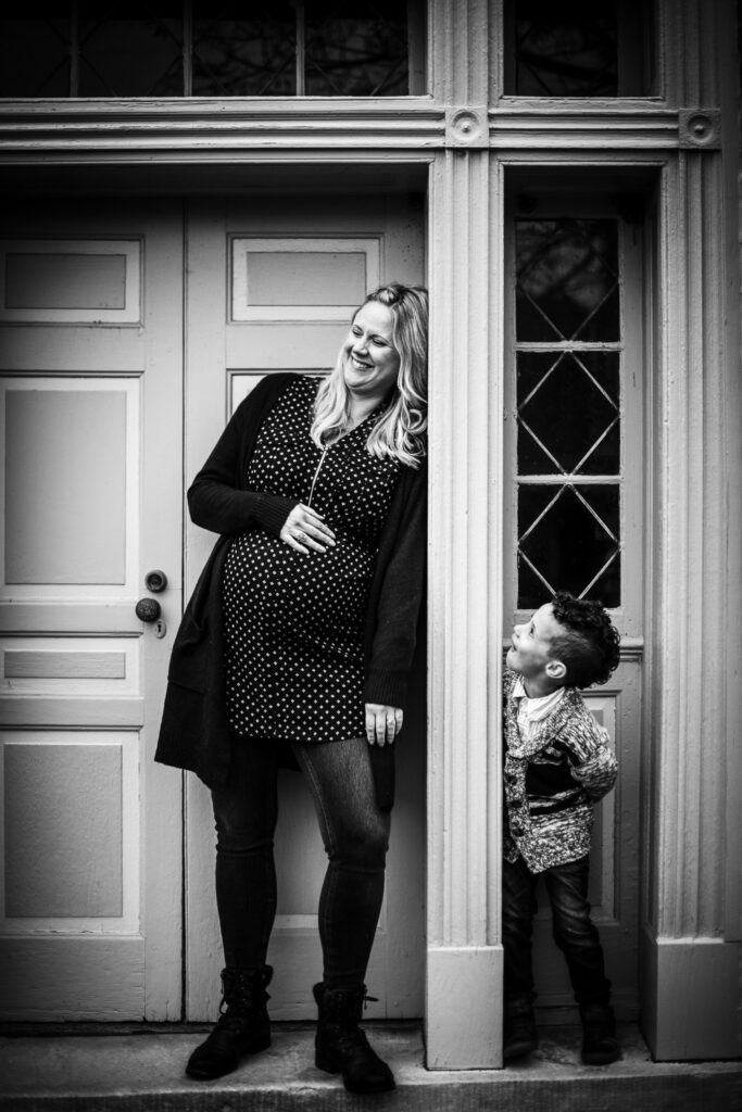 pregnant mother laughing at son in front of door