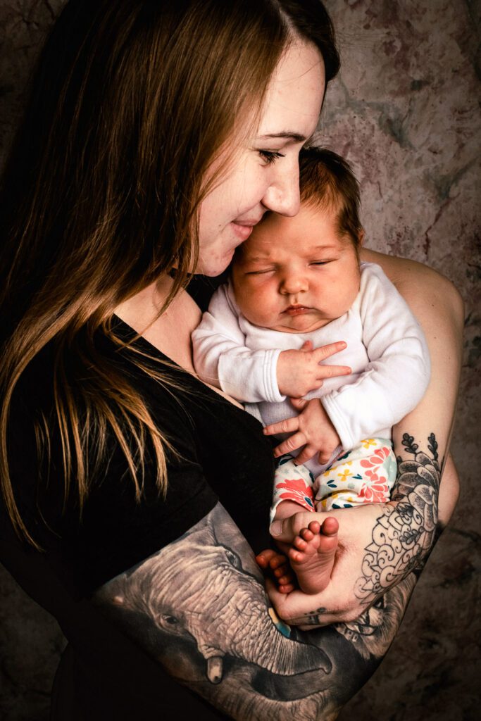 mother with tattoos holding newborn in Columbia, MO