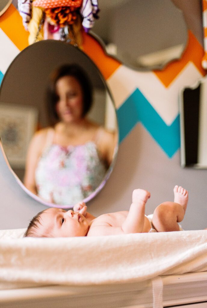 mother watching newborn in mirror reflection in Columbia, MO