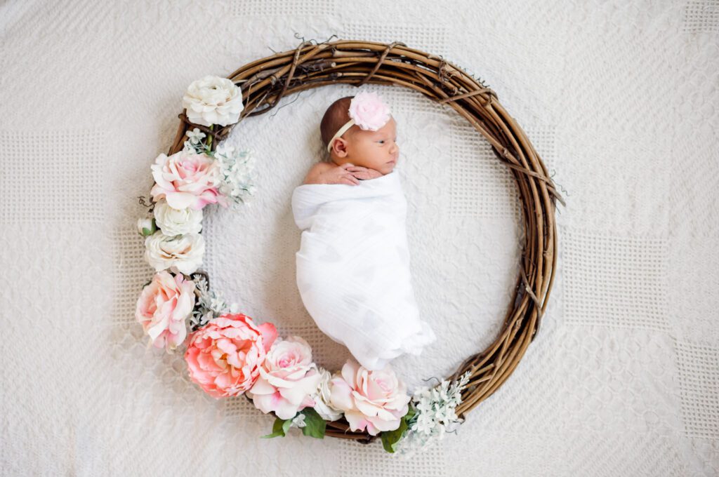 newborn wrapped in swaddle inside flower wreath in Columbia, MO