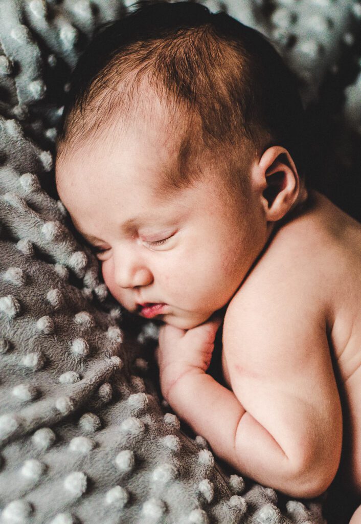 newborn baby curled up on minky gray blanket in Columbia, MO
