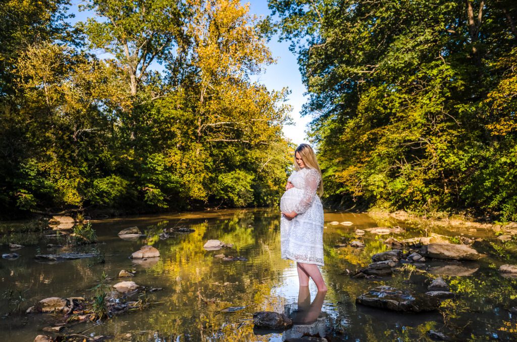 pregnant girl wading in water in dress