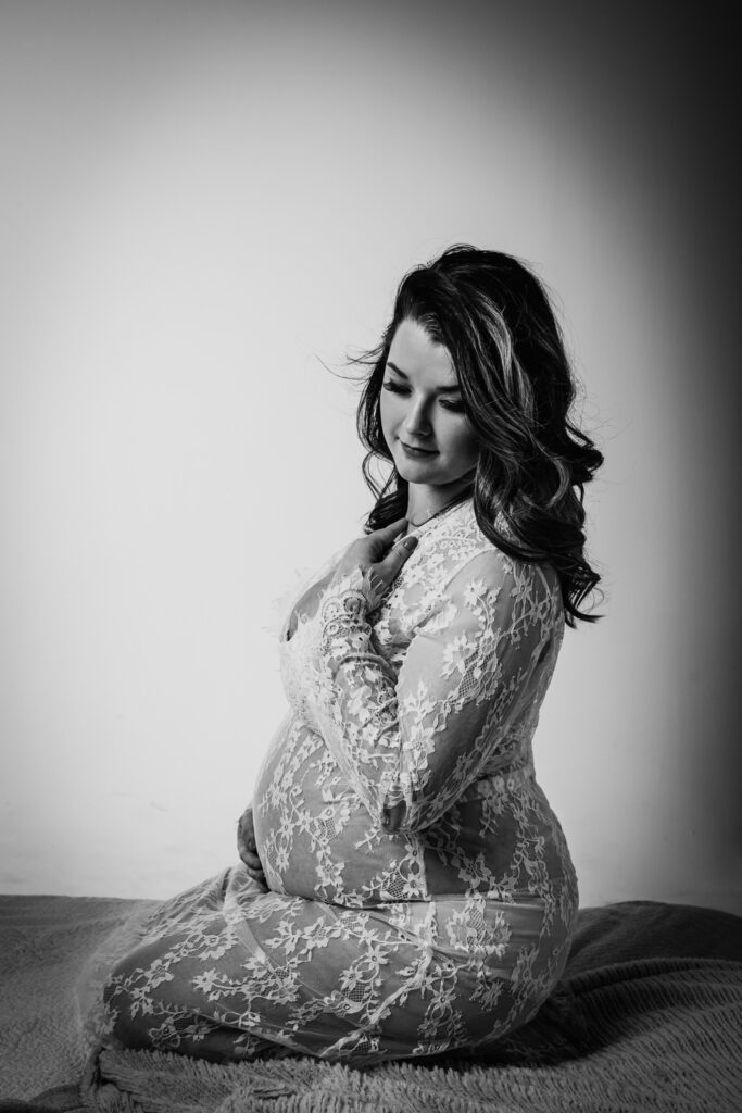 pregnant woman on bed in sheer lacy gown