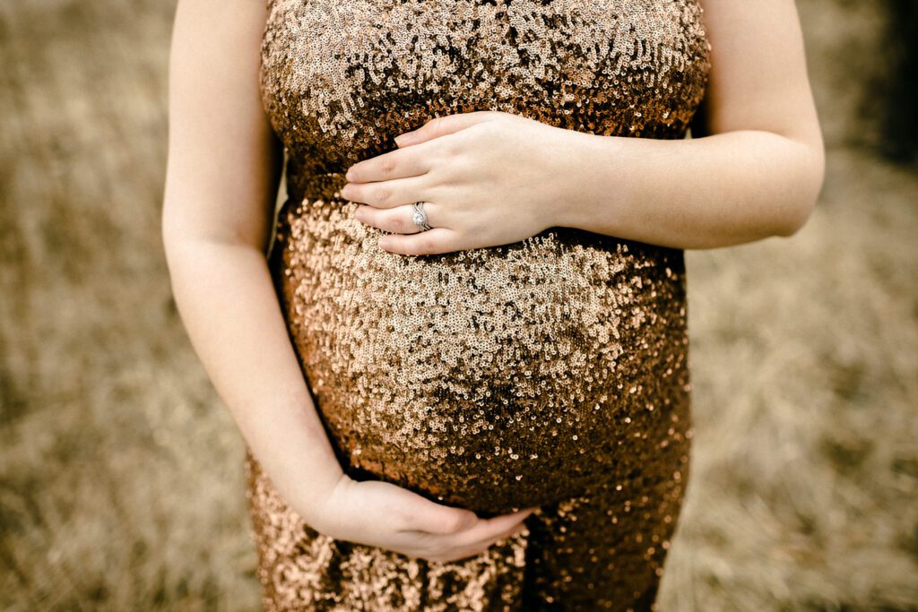 pregnant lady in sequin dress holding belly