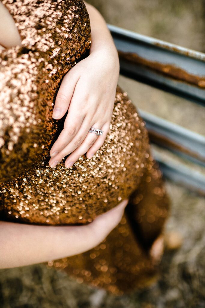 pregnant woman holding stomach in sequin evening gown