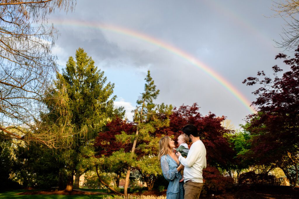 Family play together under rainbow