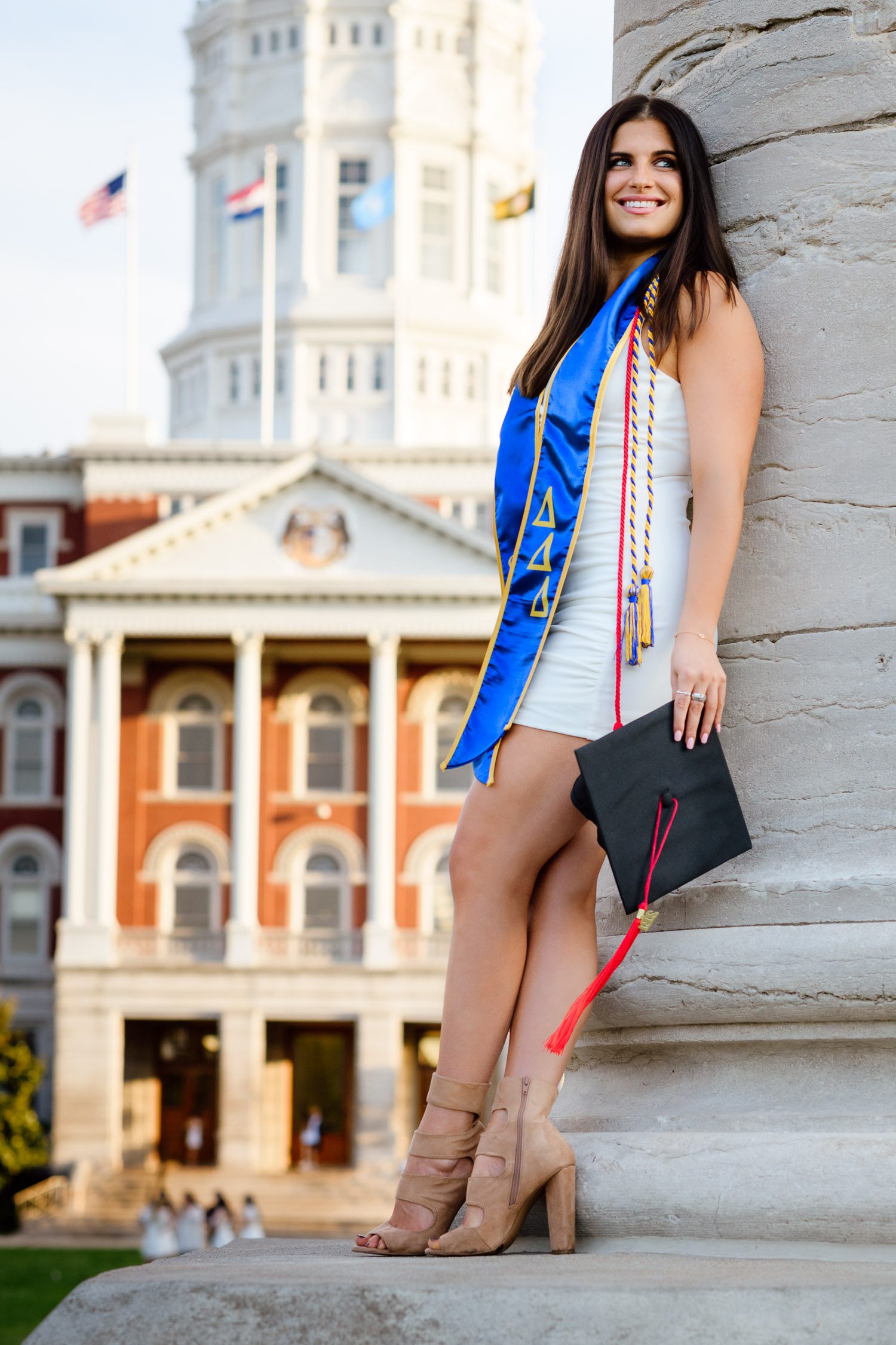 College graduate girl stands on mizzou column