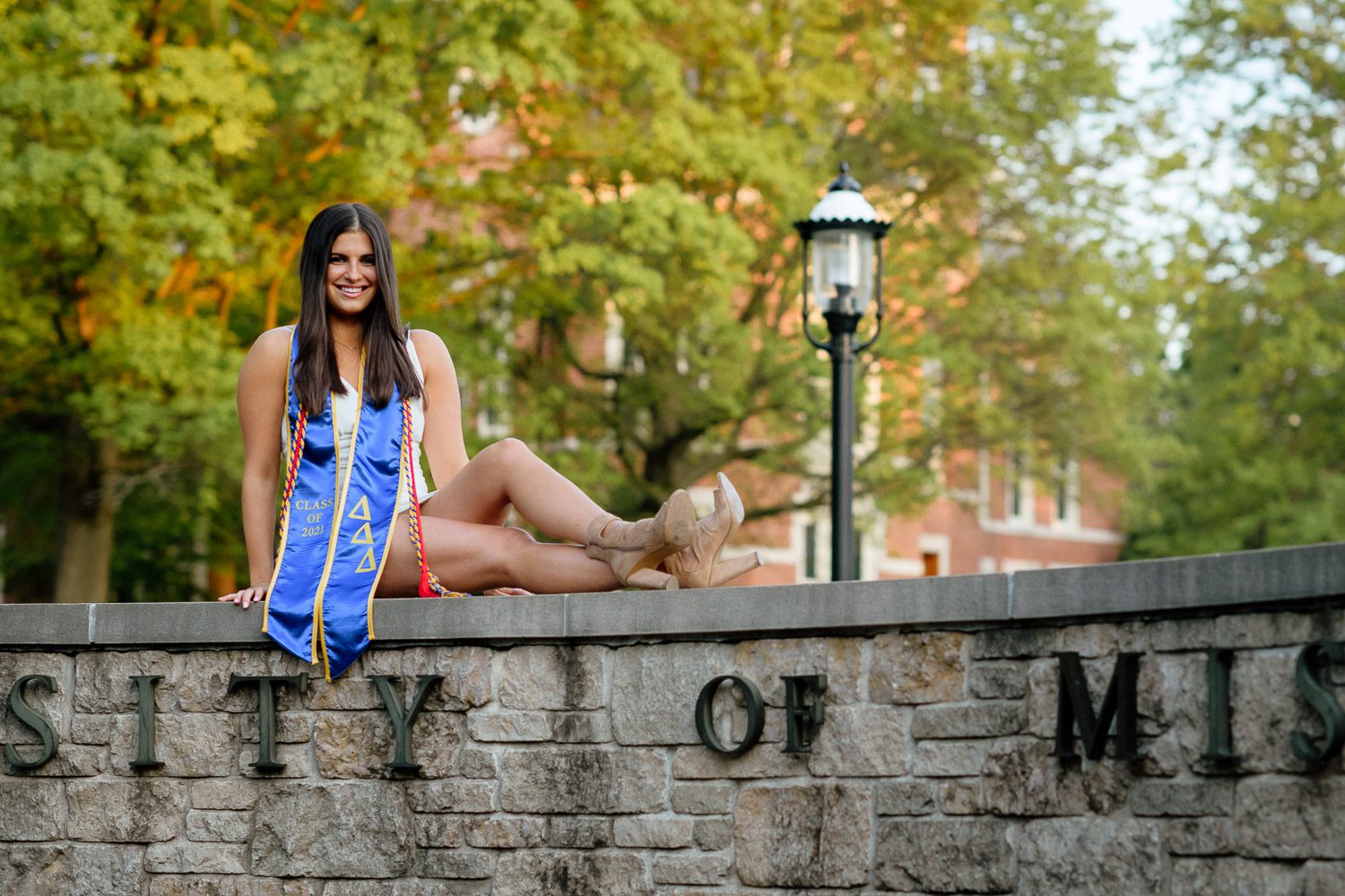 Senior Mizzou student sits on rock sign