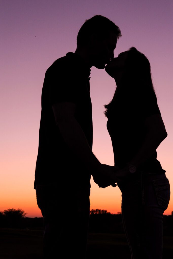 couple kiss during sunset engagement shoot