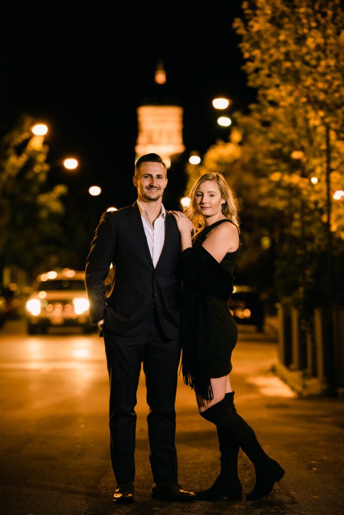 Couple wearing formal dress stand in street by Jesse Hall