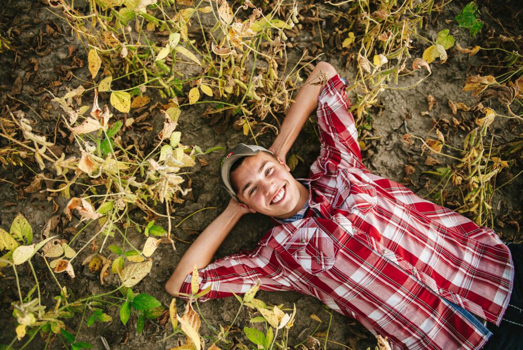 senior guy farmer laying in bean field
