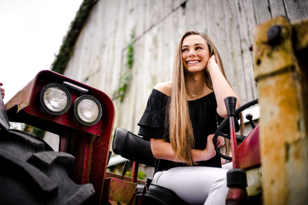 Senior girl sitting on tractor