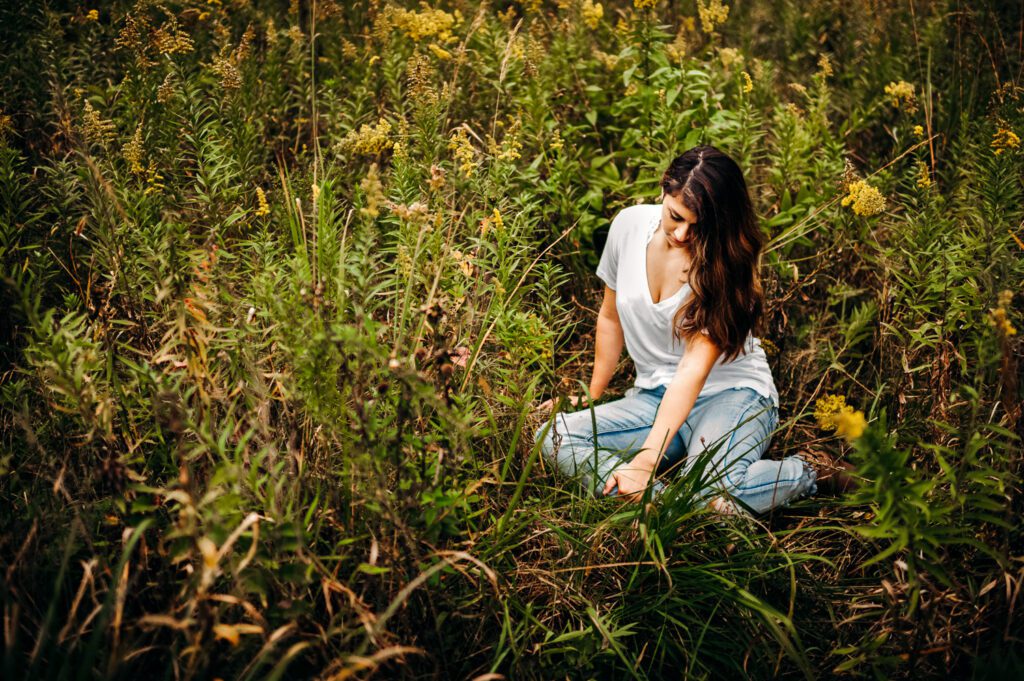 senior girl sitting in field goldenrod