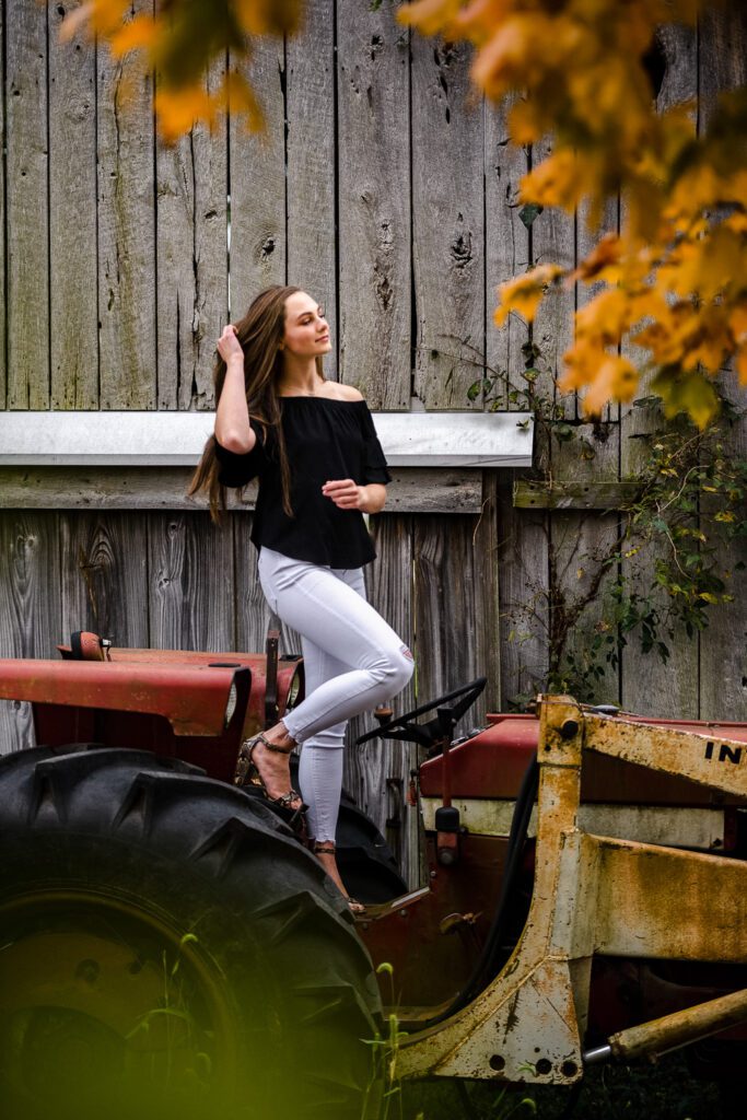 senior girl standing on tractor