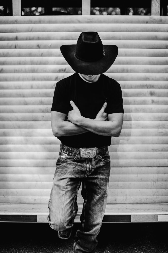 senior guy leaning on horse trailer cowboy